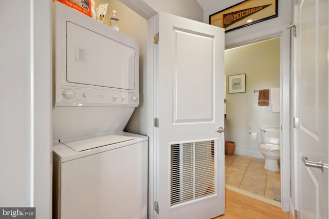 washroom with light tile patterned flooring and stacked washer and clothes dryer