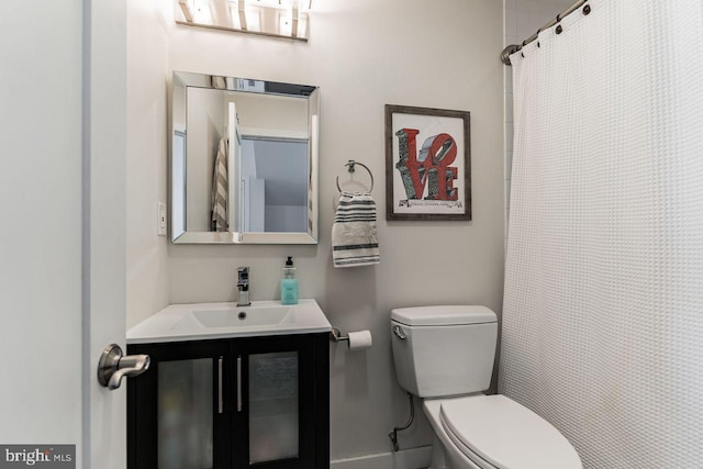 bathroom featuring vanity, toilet, and walk in shower