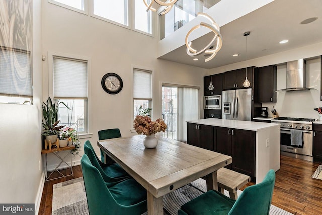 kitchen featuring wall chimney exhaust hood, a center island, dark hardwood / wood-style floors, and stainless steel appliances