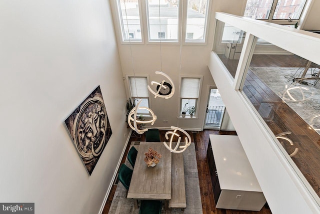 interior space featuring a towering ceiling and dark wood-type flooring