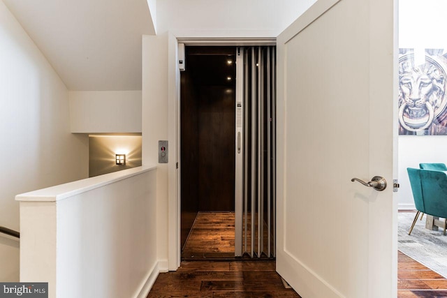 hall featuring elevator and dark hardwood / wood-style flooring