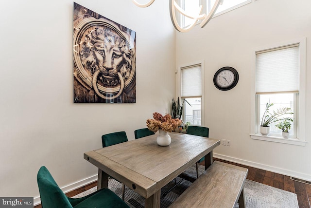 dining room featuring a notable chandelier, plenty of natural light, and dark hardwood / wood-style flooring