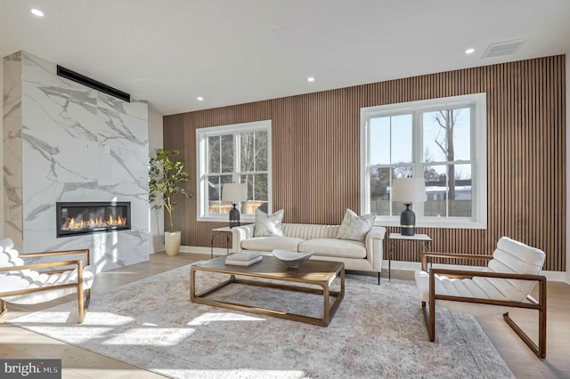 living room with a premium fireplace and light wood-type flooring