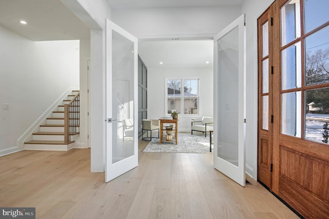 foyer entrance featuring french doors and light hardwood / wood-style floors