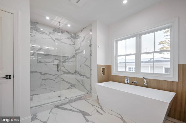 bathroom with plus walk in shower, wooden walls, and plenty of natural light