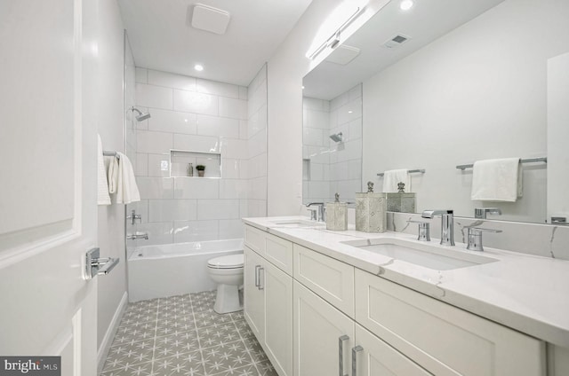 full bathroom with toilet, vanity, and tiled shower / bath