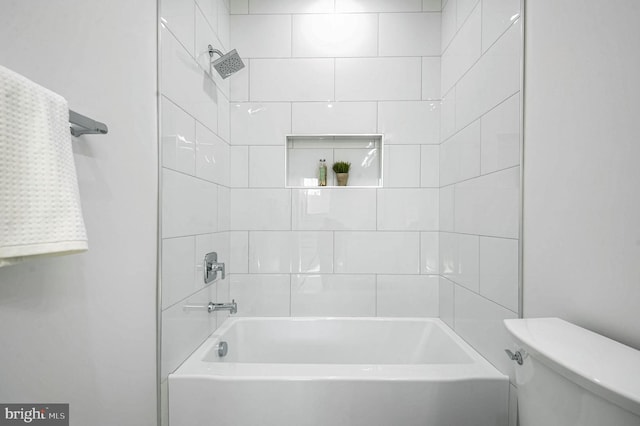 bathroom featuring toilet and tiled shower / bath combo