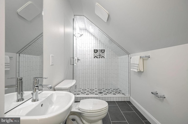 bathroom featuring toilet, tiled shower, tile patterned floors, and sink