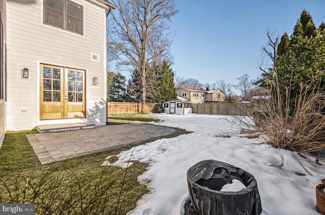 view of yard with french doors, a storage unit, and a patio area