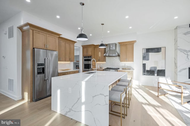 kitchen with a large island, stainless steel appliances, wall chimney range hood, and backsplash