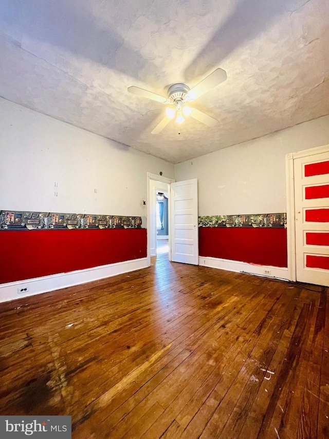 unfurnished room with a textured ceiling, wood-type flooring, and ceiling fan