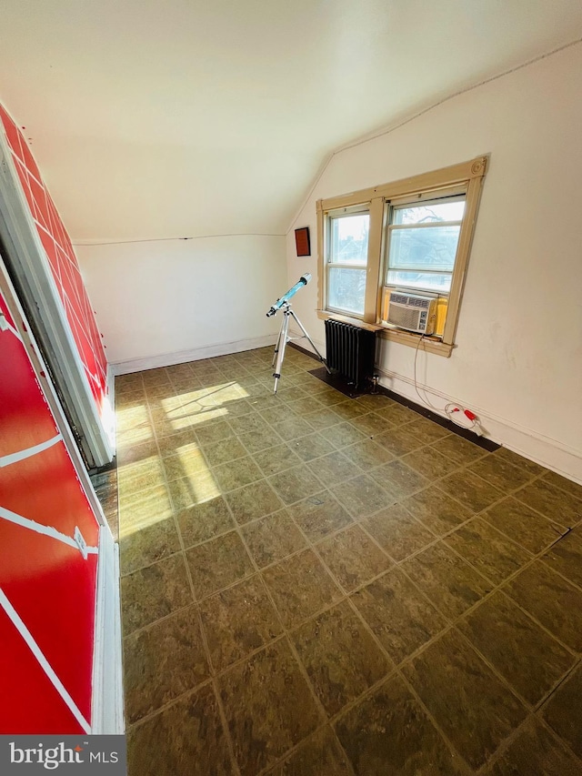 interior space with vaulted ceiling, radiator heating unit, and cooling unit