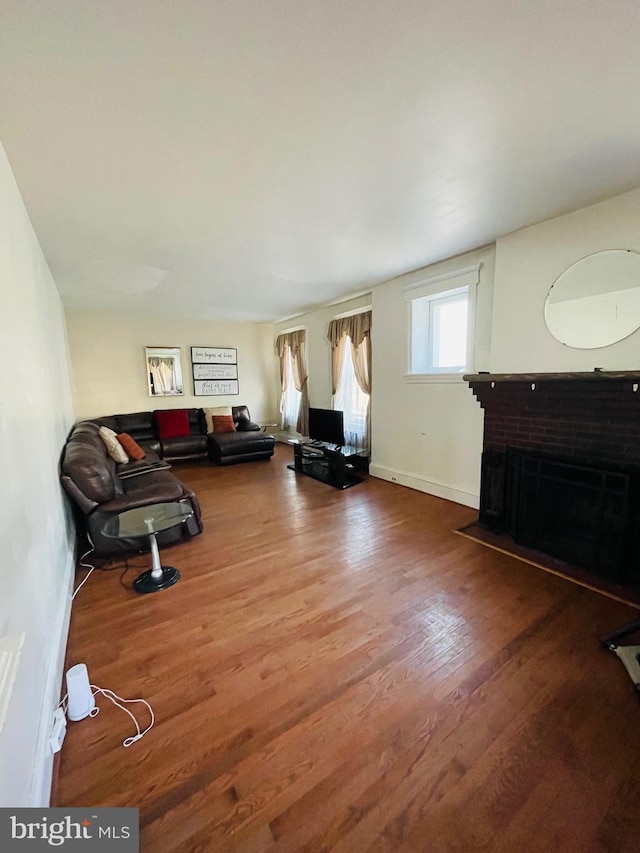 living room featuring hardwood / wood-style floors and a brick fireplace