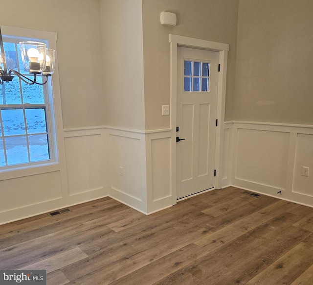 entryway featuring wood-type flooring and a chandelier