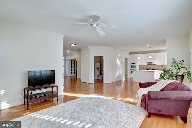 living room featuring light wood-type flooring and ceiling fan