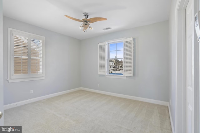 carpeted spare room featuring ceiling fan