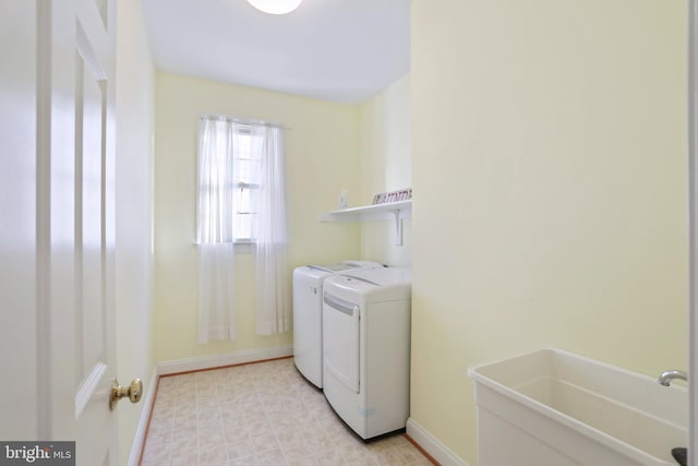 washroom with separate washer and dryer and sink