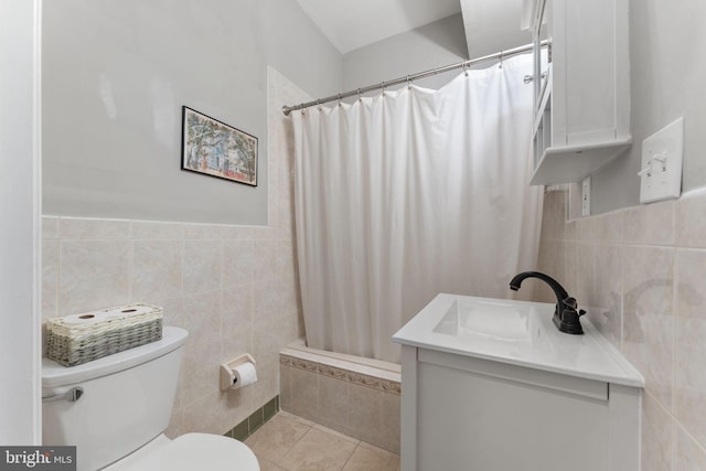 full bathroom with tile patterned floors, vanity, shower / tub combo, tile walls, and toilet