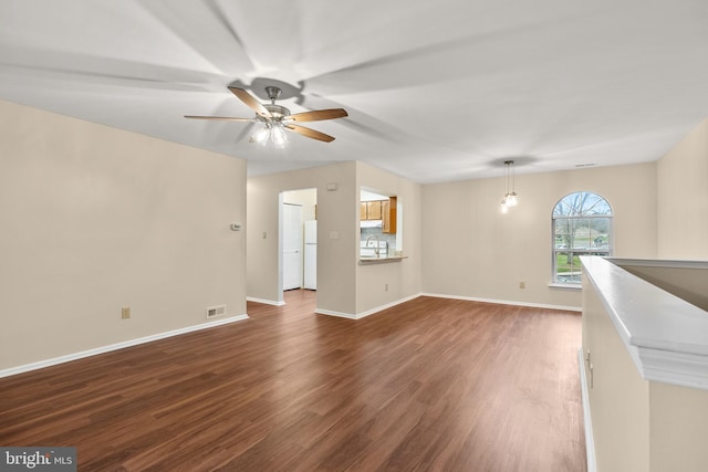 unfurnished living room with ceiling fan, dark wood-type flooring, and sink