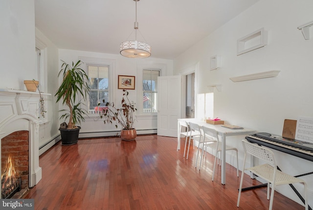 dining space with baseboard heating, dark hardwood / wood-style floors, and a wealth of natural light