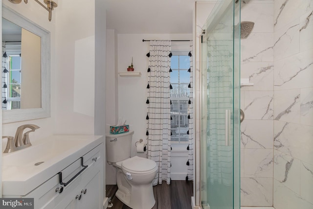 bathroom featuring toilet, a shower with door, wood-type flooring, a wealth of natural light, and vanity