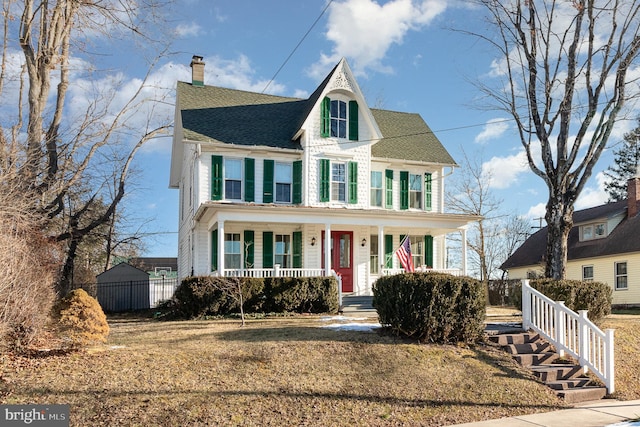 victorian home featuring covered porch and a front lawn