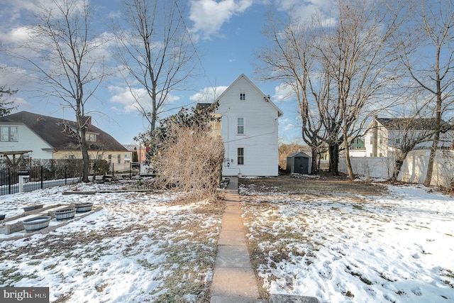 view of snowy exterior with a shed