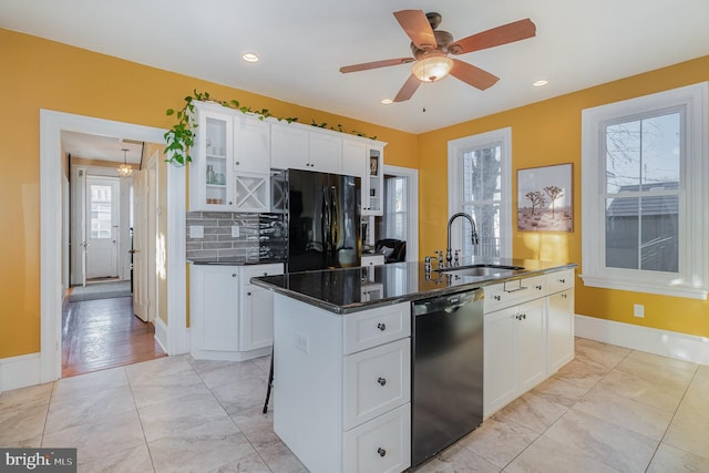 kitchen featuring black appliances, white cabinetry, sink, ceiling fan, and a center island with sink