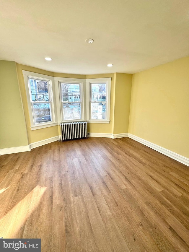 empty room featuring light hardwood / wood-style flooring and radiator