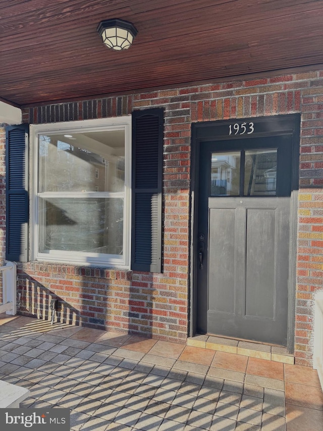 entrance to property featuring brick siding