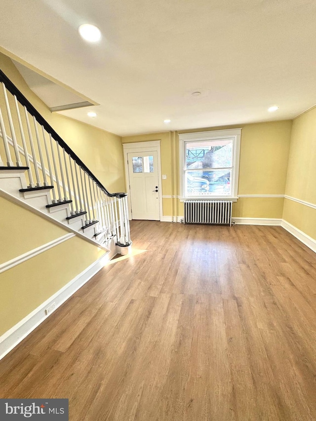 foyer entrance featuring light hardwood / wood-style floors and radiator