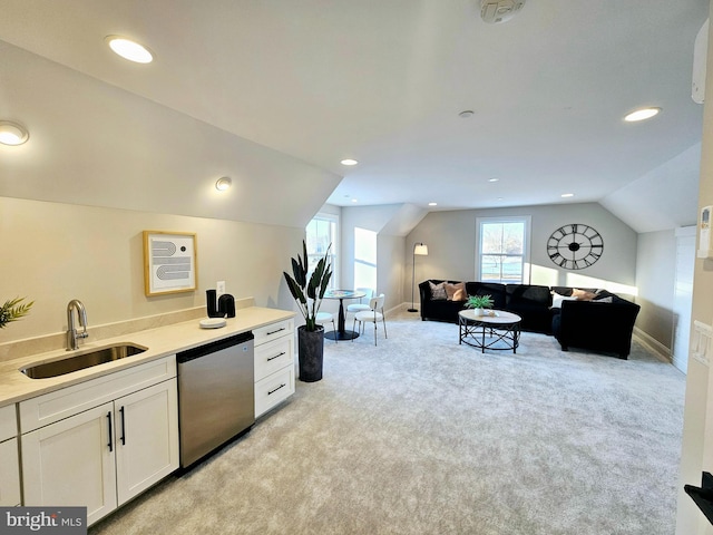 kitchen featuring light colored carpet, vaulted ceiling, sink, white cabinetry, and dishwashing machine