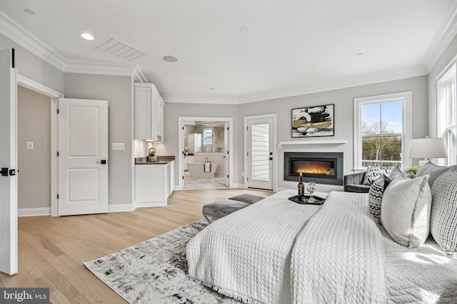 bedroom featuring crown molding, connected bathroom, and light hardwood / wood-style floors