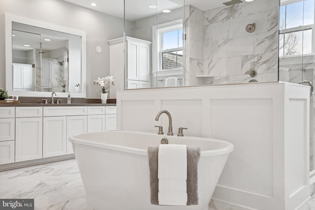 bathroom featuring vanity and independent shower and bath