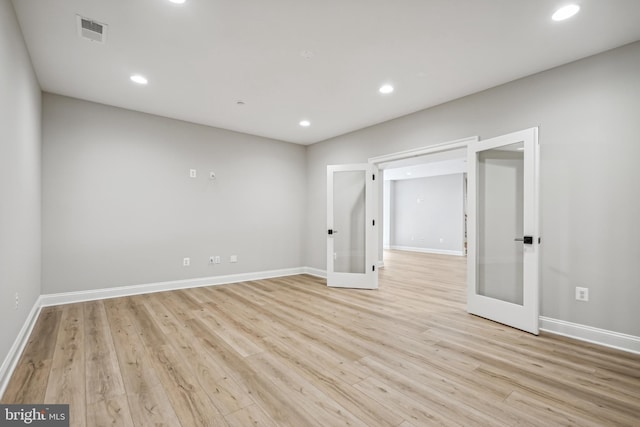 empty room with french doors and light hardwood / wood-style floors