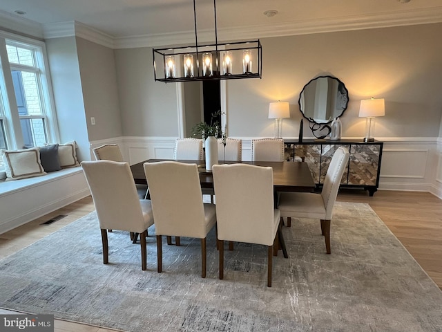 dining room featuring ornamental molding, a chandelier, and hardwood / wood-style flooring