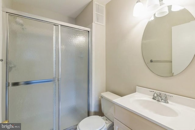 bathroom with a shower with shower door, vanity, and toilet