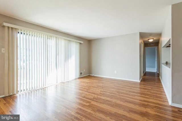 empty room with hardwood / wood-style floors and a wealth of natural light