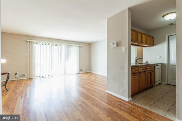 kitchen featuring white dishwasher, light hardwood / wood-style floors, and sink