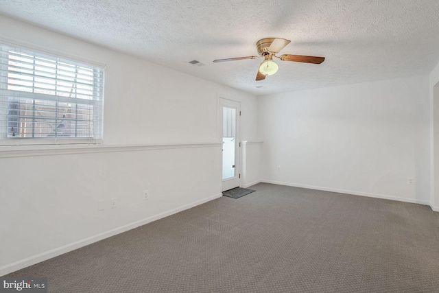 carpeted spare room featuring ceiling fan and a textured ceiling