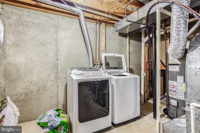 clothes washing area featuring washer and clothes dryer and gas water heater