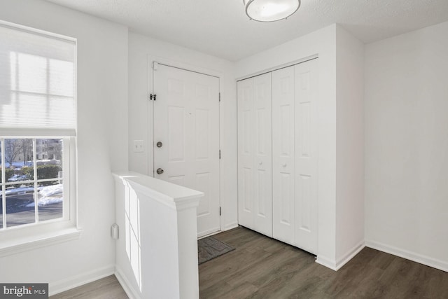 foyer featuring a textured ceiling and dark hardwood / wood-style floors