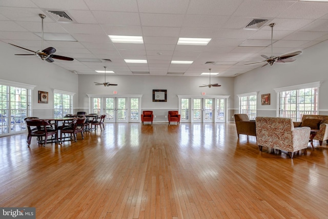 interior space featuring light hardwood / wood-style floors, a paneled ceiling, french doors, and a wealth of natural light