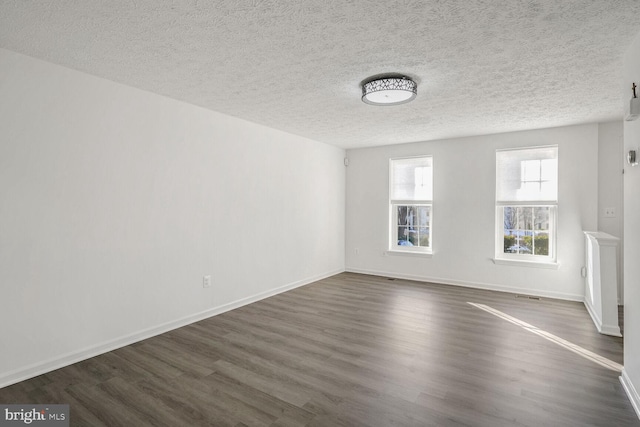 empty room featuring dark hardwood / wood-style flooring and a textured ceiling