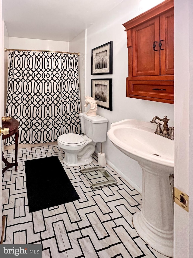 bathroom with toilet and a shower with curtain