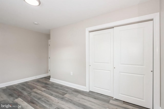 unfurnished bedroom featuring a closet and wood-type flooring