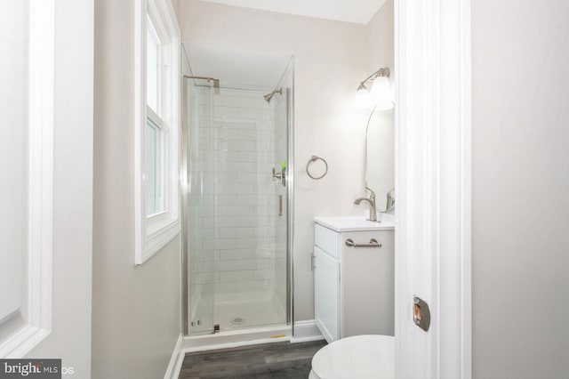 bathroom with hardwood / wood-style floors, vanity, toilet, and a shower with shower door