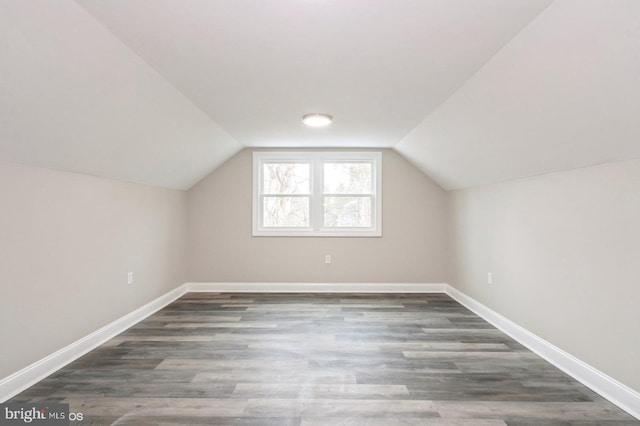 additional living space featuring lofted ceiling and dark wood-type flooring