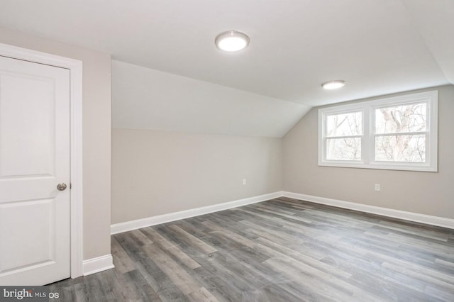 additional living space featuring dark hardwood / wood-style flooring and vaulted ceiling