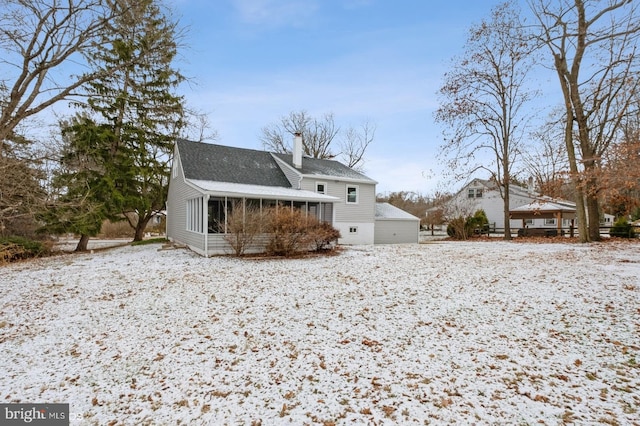 snow covered property featuring a sunroom